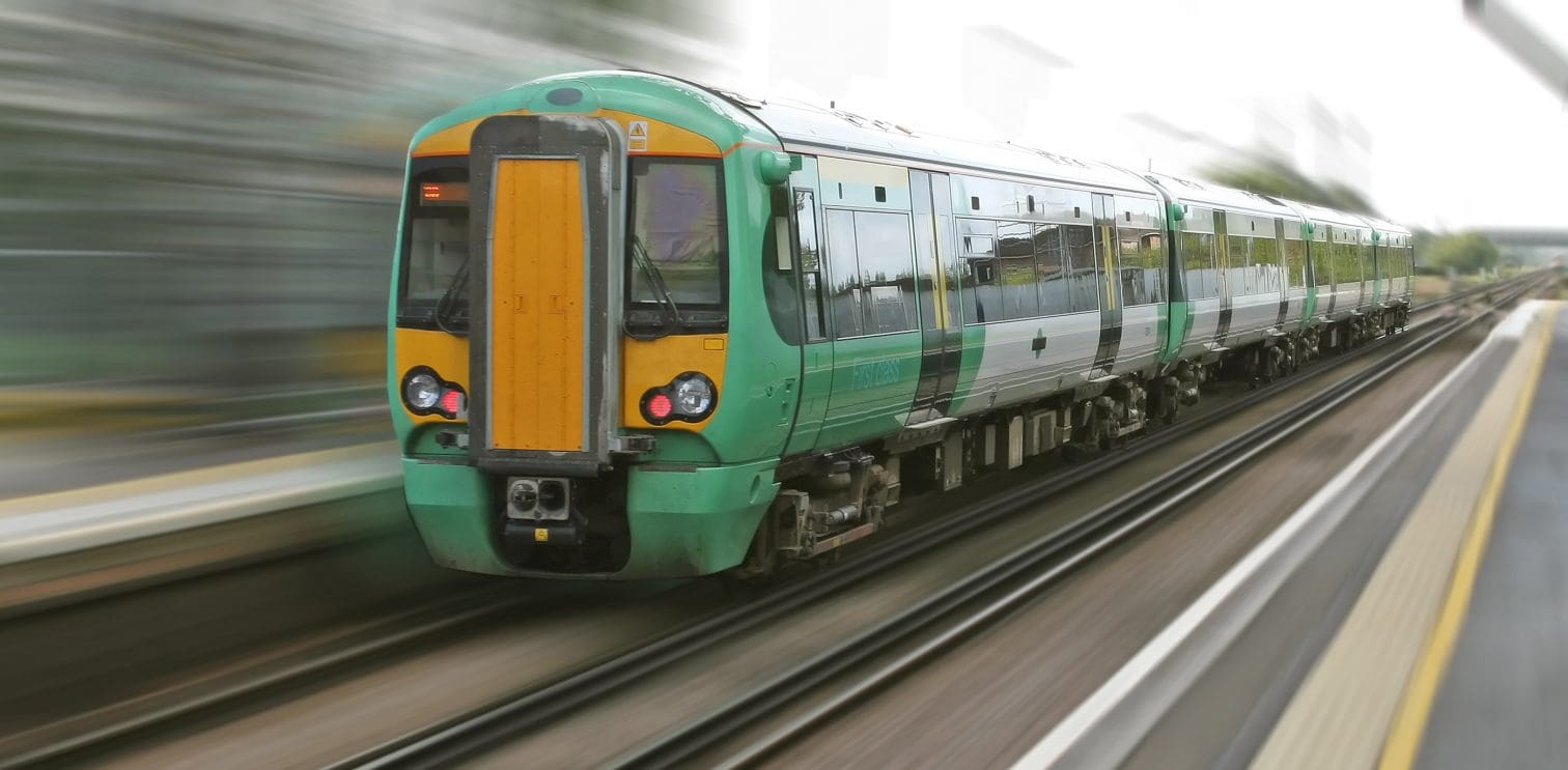 green and yellow train travelling fast on a train track. Railway equipment by GD Rectifiers.